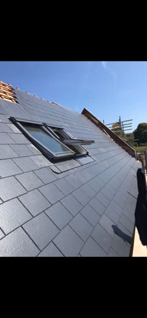 Slate roof with skylight under blue sky