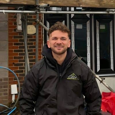 Connor Stanley, co-owner of C J Roofing & Renewables, wearing a branded jacket on site.
