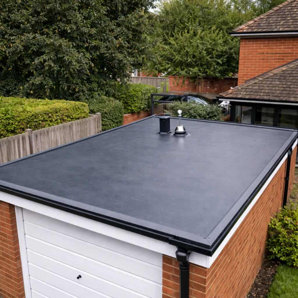Black EPDM rubber flat roof on a domestic garage, with neat edge trims and a black downpipe.