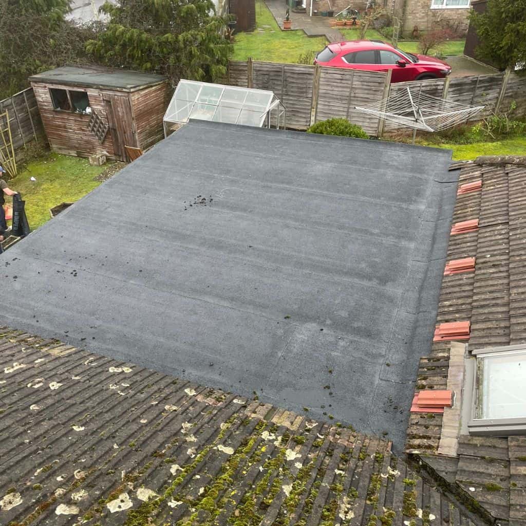 Dark grey standing-seam metal roof on a barn-style building, with battens exposed on an adjoining roof section.