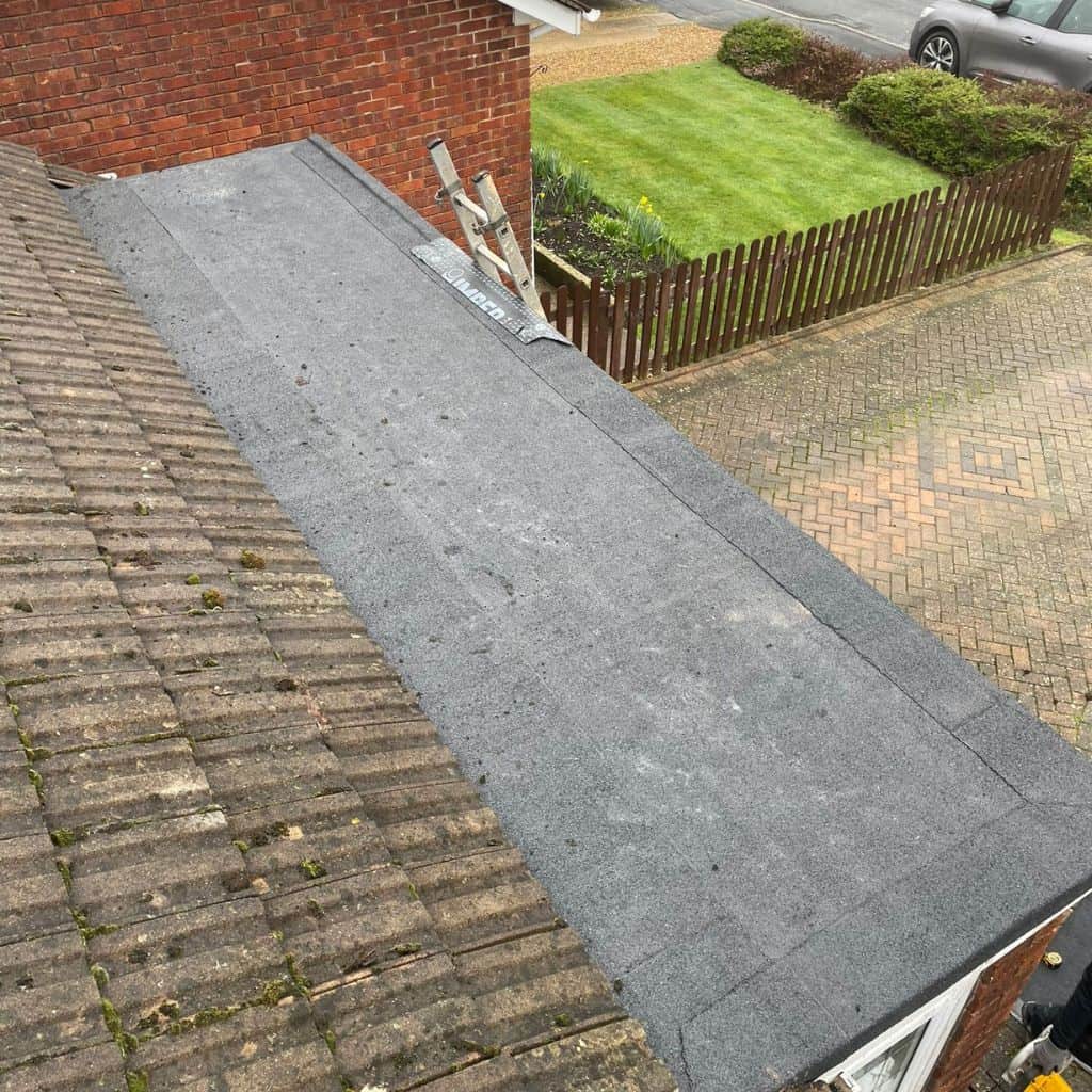 Newly laid OSB timber deck on a flat roof extension ready for waterproofing, overlooking a garden.
